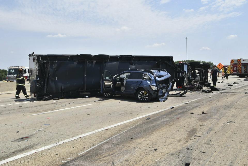 In this image taken Sunday, July 14, 2019, and provided by the Indianapolis Fire Department, emergency personnel work at the scene of fatal crash along Interstate 465 in Indianapolis. Authorities say a woman and her 18-month-old twin daughters died in the fiery, seven-vehicle crash on an Indianapolis freeway. (Battalion Chief Rita L. Reith/Indianapolis Fire Department via AP)