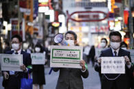 Staff of the Tokyo Metropolitan Government urge people to go home from the Kabukicho entertainment district in the Shinjuku Ward in Tokyo, Friday evening, April 24, 2020. Japan's Prime Minister Shinzo Abe expanded a state of emergency to all of Japan from just Tokyo and other urban areas as the virus continues to spread. (AP Photo/Eugene Hoshiko)