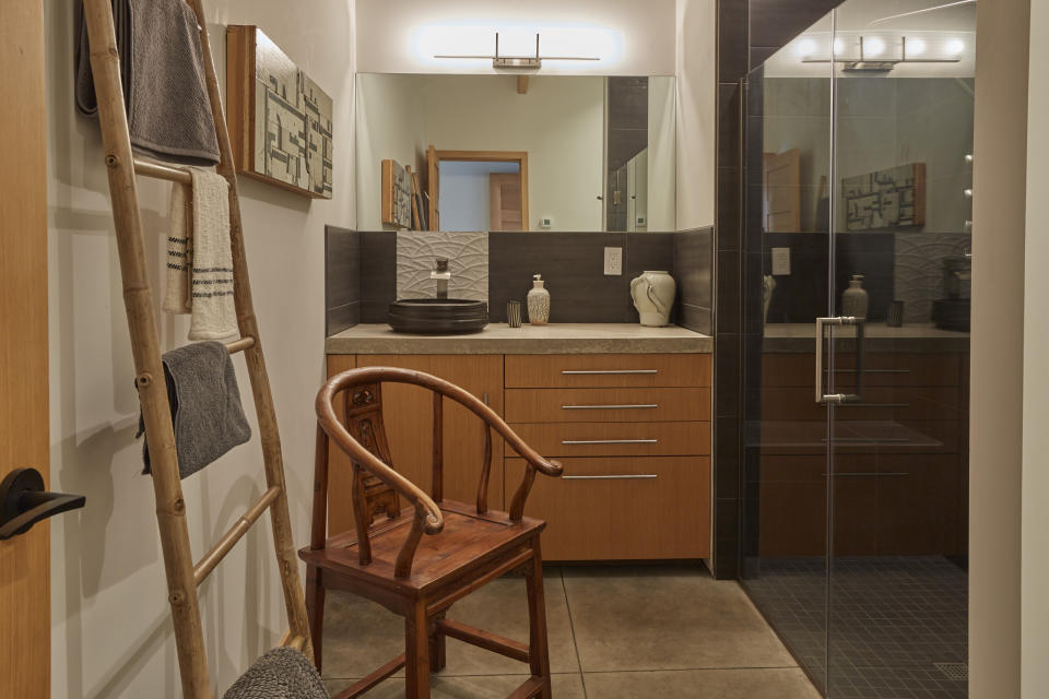 This photo provided by Patrick Barta/Taunton Press shows a photo of a home on Whidbey Island, Wash., featured in the book "downsize: Livinglarge in a small house," by Sheri Koones. The curbless shower in the Asian-inspired master suite transitions seamlessly from the bathroom floor to the shower. (Patrick Barta/Taunton Press via AP)