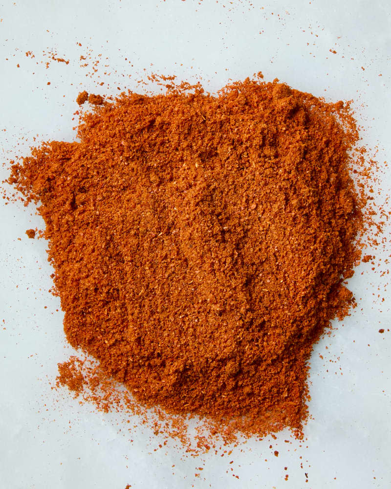 overhead shot of smoked paprika on a white marble surface.