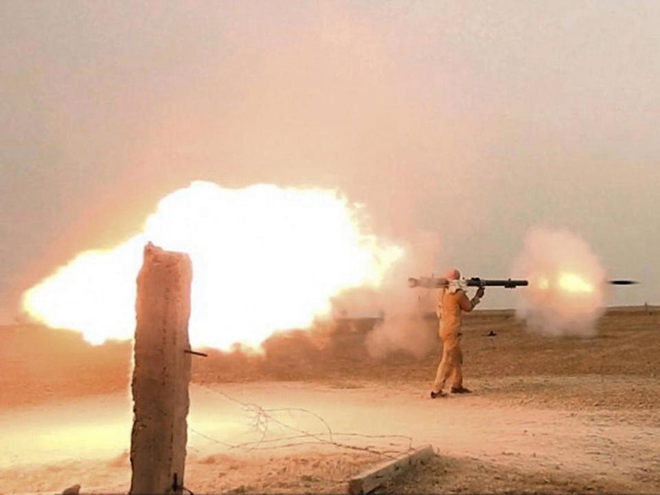 An Islamic State fighter firing his weapon during clashes with US-backed Kurdish-led Syrian Democratic Forces, in the northern Syrian province of Raqqa (AP)