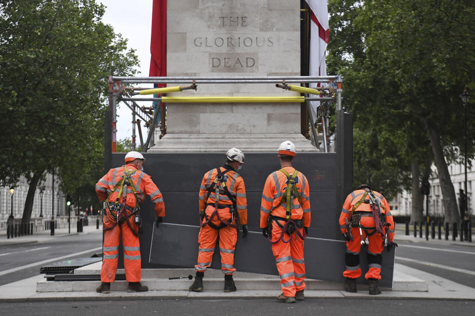 Scaffolders erect boarding around the Cenotaph on Whitehall, in London, Thursday, June 11, 2020, following Black Lives Matter protests that took place across the U.K. over the weekend. The protests were ignited by the death of George Floyd, a black man, who died after he was restrained in Minneapolis police custody on May 25 in the U.S. (Kirsty O'Connor/PA via AP)