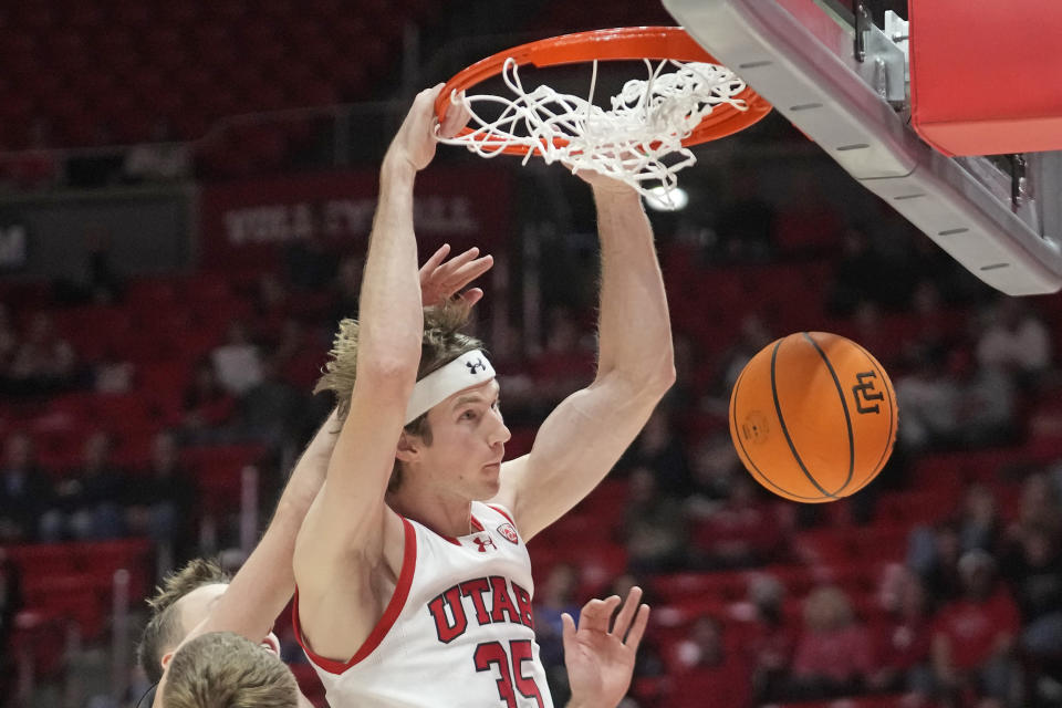 Utah center Branden Carlson dunks against Washington during the second half of an NCAA college basketball game, Sunday, Dec. 31, 2023, in Salt Lake City. (AP Photo/Rick Bowmer)