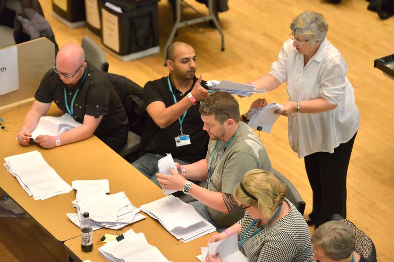 Counting agents tallying up votes at a previous election.