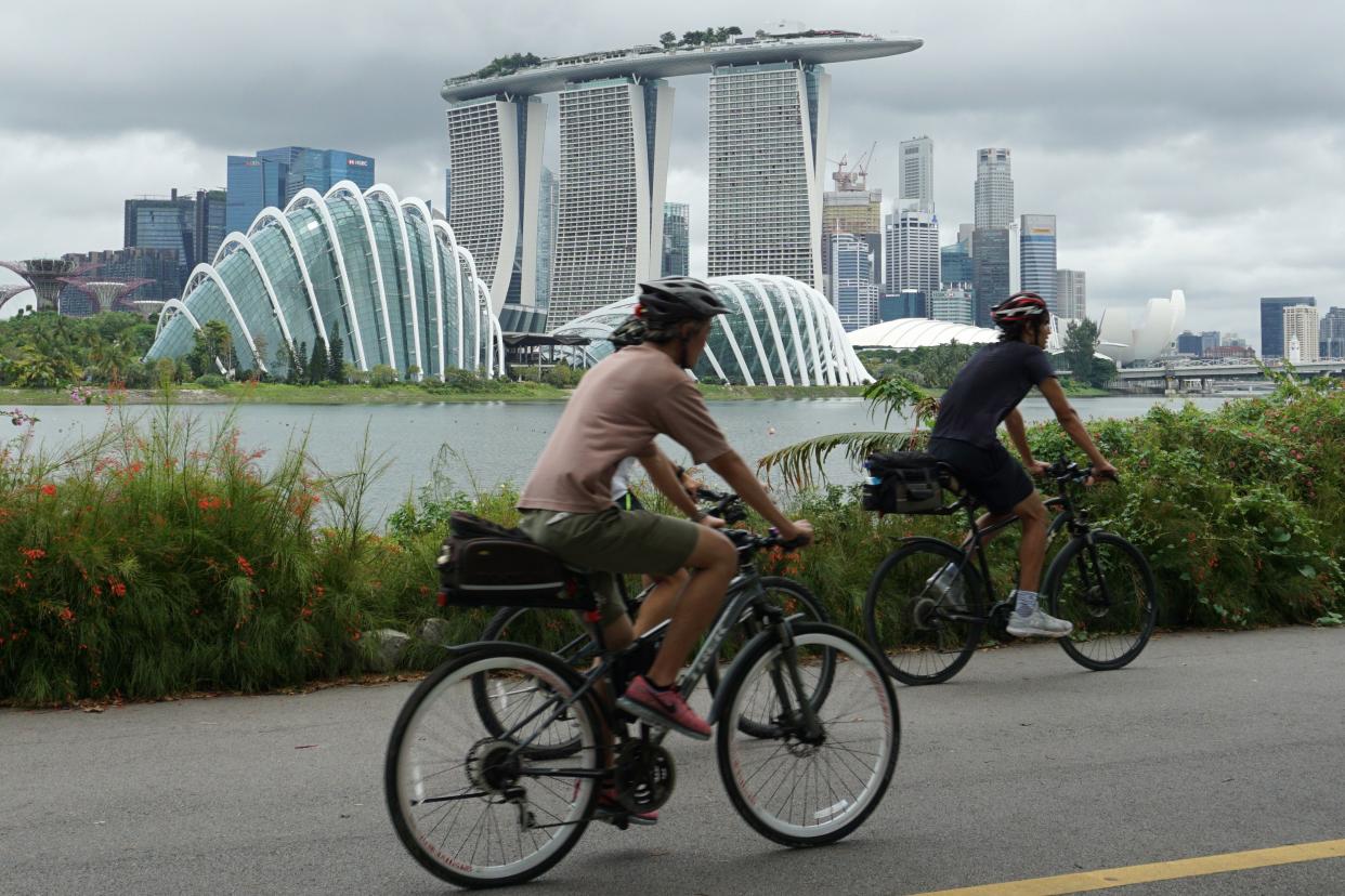 Cyclists ride along Marina Bay overlooking the financial business district in Singapore on July 14, 2020. - Singapore plunged into recession in the second quarter as the economy contracted more than 40 percent, preliminary data showed on July 14, with the trade-dependent city state hammered by the coronavirus in another ominous sign for the global recovery. (Photo by Roslan RAHMAN / AFP) (Photo by ROSLAN RAHMAN/AFP via Getty Images)