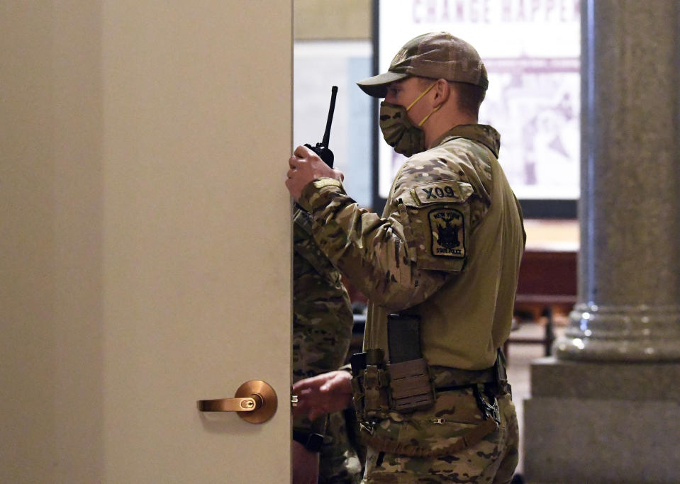 New York state Police wearing tactical gear patrol the hallways of the state Capitol prior to a planned President Trump protest rally ahead of the inauguration of President-elect Joe Biden and Vice President-elect Kamala Harris Sunday, Jan. 17, 2021, in Albany, N.Y. (AP Photo/Hans Pennink)