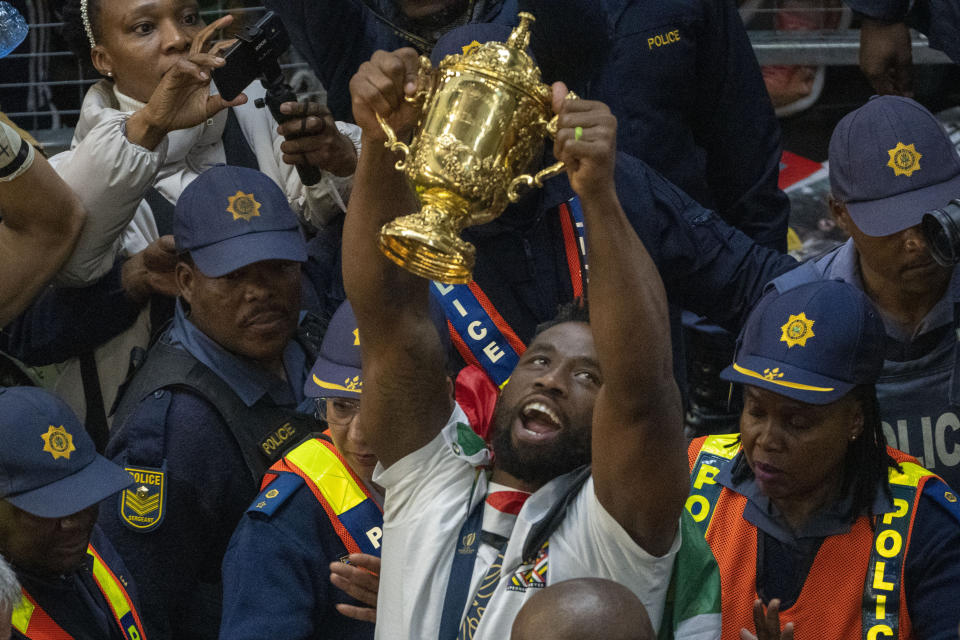 South Africa' Springbok captain Siya Kolisi holds the Webb Ellis cup after arriving with other players at O.R Tambo's international airport in Johannesburg, South Africa, Tuesday Oct. 31, 2023. (AP Photo/Jerome Delay)