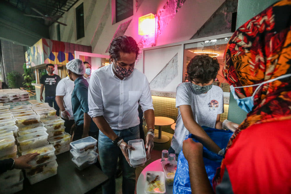 Minister of Science, Technology, and Innovation Khairy Jamaluddin hands over meals for distribution during the ECM Libra Foundation and Pertiwi Covid-19 Food Aid Programme in Kuala Lumpur August 14, 2020. — Picture by Firdaus Latif