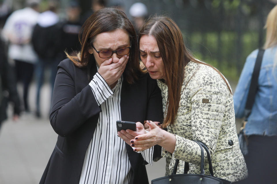 Women look a the screen of a mobile phone in Belgrade, Serbia, Wednesday, May 3, 2023. Serbian police say a teenage boy opened fire at a school in central Belgrade, killing several children and hospitalizing several more. (AP Photo/Milos Miskov)