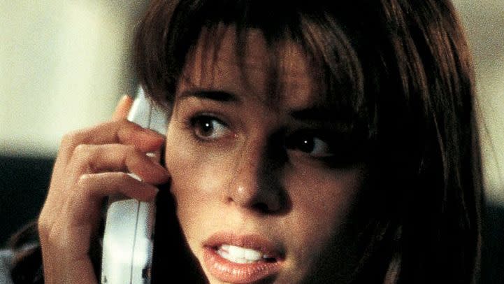 sidney prescott urgently takes a phone call in a scene from scream a good housekeeping pick for best halloween movies