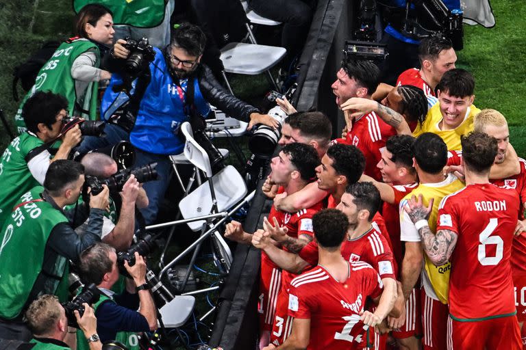 Los compañeros de equipo celebran después de que el delantero de Gales Gareth Bale (parcialmente cubierto) anotó el empate de su equipo durante el partido del Grupo B de la Copa Mundial de Qatar 2022 entre EE. UU. Y Gales en el Estadio Ahmad Bin Ali en Al-Rayyan, al oeste de Doha el 21 de noviembre de 2022.