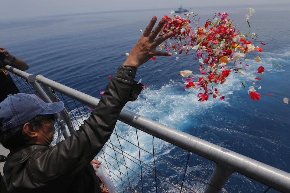 JT610的罹難者家屬向海中獻花。（圖／美聯社資料照）