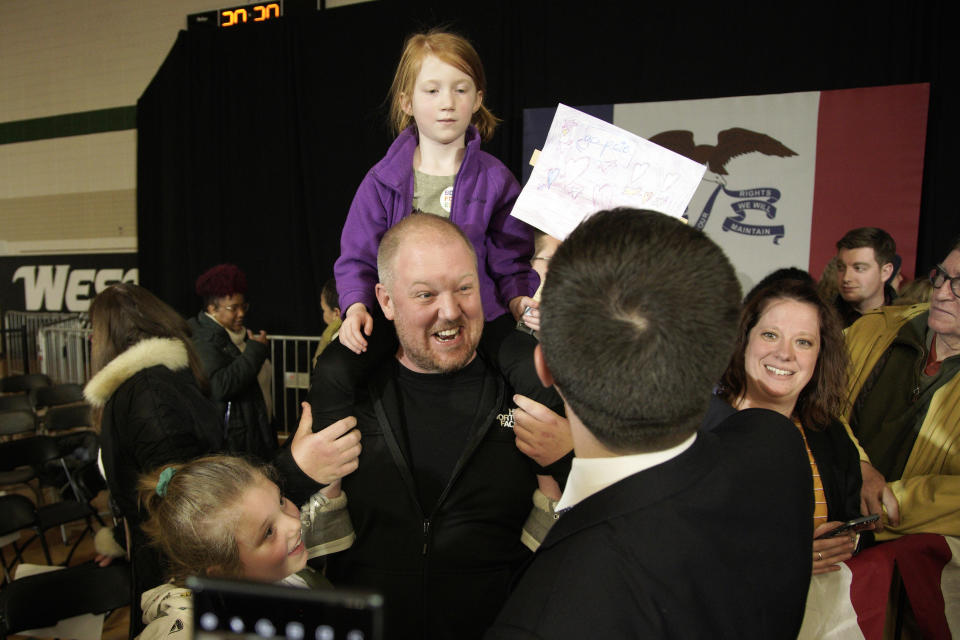 Travis Monk of Sioux City with daughters Hazel, top, and Eva, bottom left, meet with Democratic presidential candidate and former South Bend Mayor Pete Buttigieg following an election rally in Sioux City, Iowa, Thursday, Jan. 16, 2020. (AP Photo/Nati Harnik)