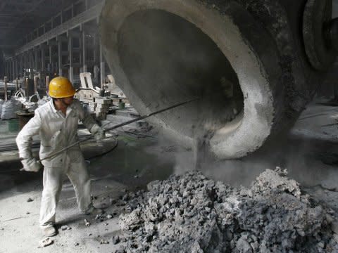 A steel worker cleans a pipe in China