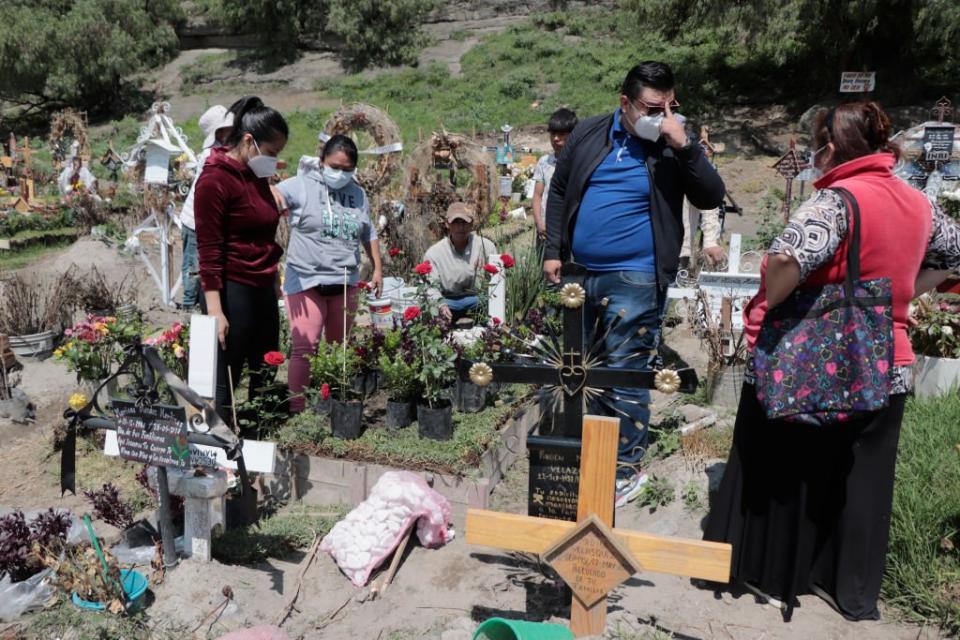 Parientes de personas fallecidas por covid-19 en un cementerio en México