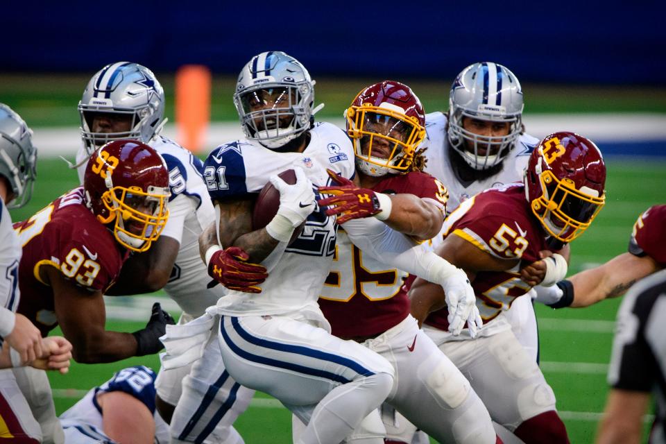 Dallas Cowboys running back Ezekiel Elliott is tackled by Washington Football Team defensive end Chase Young during Washington's 41-16 win on Thanksgiving Day 2020.