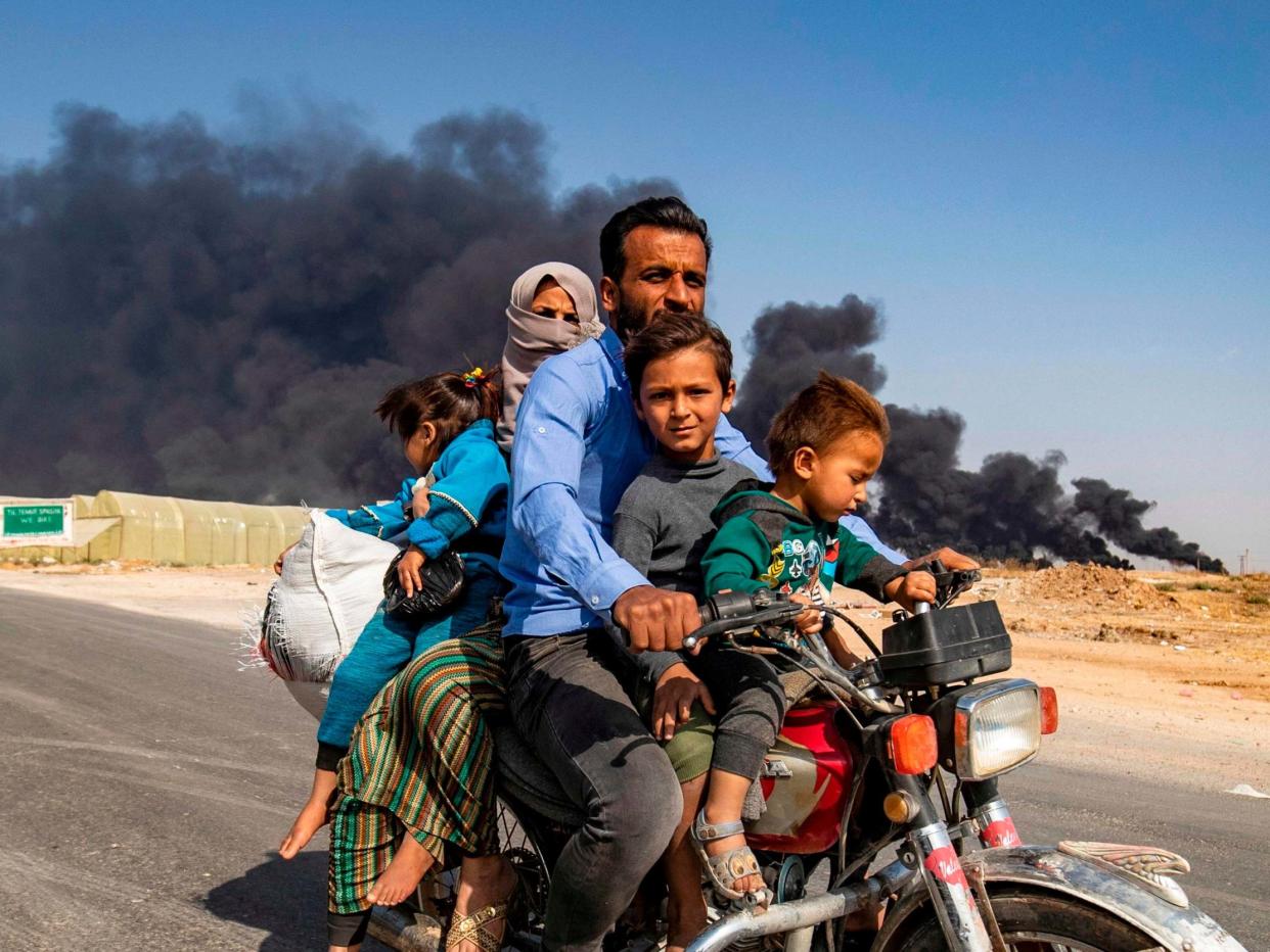 A Kurdish family flee the Syrian border city of Ras al-Ain (AFP/Getty)