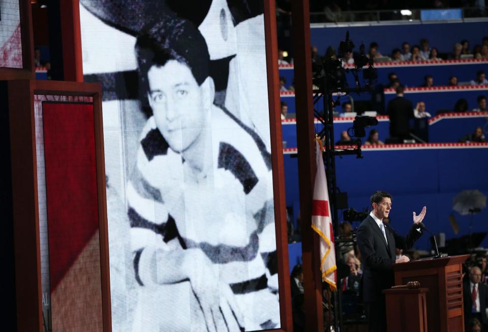 2012 Republican vice presidential nominee Paul Ryan speaks during the RNC while an old black and white photograph of him is displayed on a screen behind him.