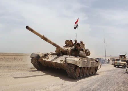 Shi'ite paramilitaries and iraqi army riding on a tank travel from Lake Tharthar towards Ramadi to fight against Islamic state militants, west of Samarra, Iraq May 27, 2015. REUTERS/Stringer