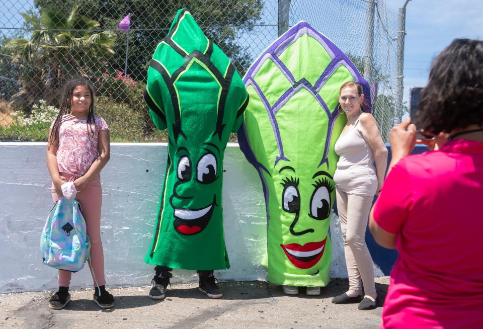 Ten-year-old Zavina Dockery, left and her mom Michele Girels pose for a picture with mascots Spearit and Spearita on opening day of the annual San Joaquin Asparagus Festival on May 13.