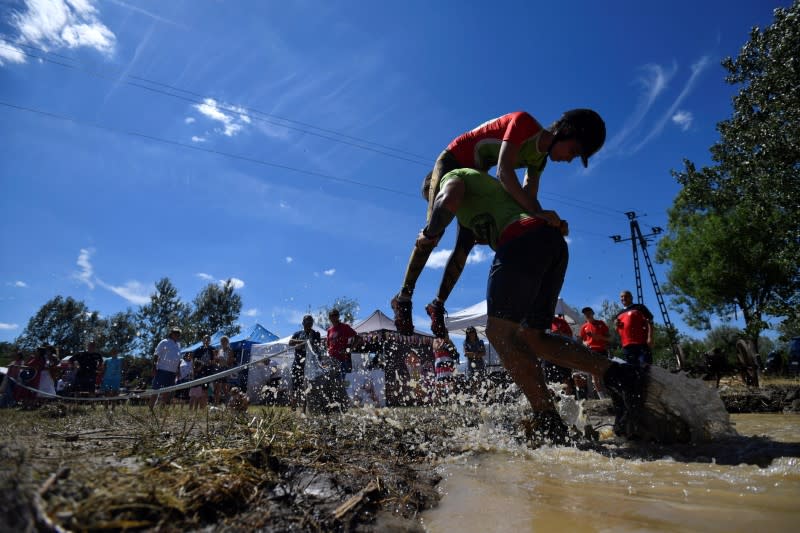 Participants compete in a wife-carrying championship