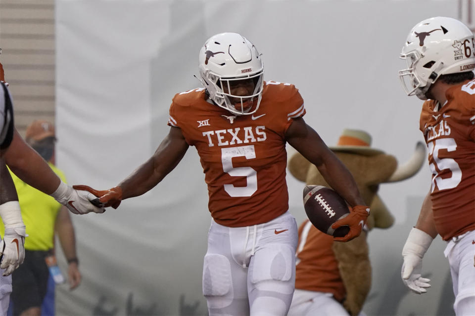 Texas running back Bijan Robinson (5) is congratulated by teammates after a touchdown against Rice during the first half of an NCAA college football game on Saturday, Sept. 18, 2021, in Austin, Texas. (AP Photo/Chuck Burton)