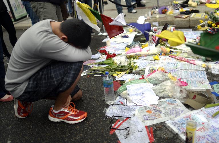 People visit a make-shift memorial on Boylston Street in Boston on April 20, 2013, near the scene of Boston Marathon bombings