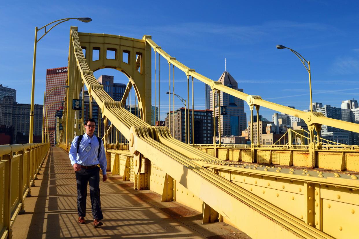 A young man walks across the Roberto Clemente Bridge during his morning commute in Pittsburgh, Pennsylvania