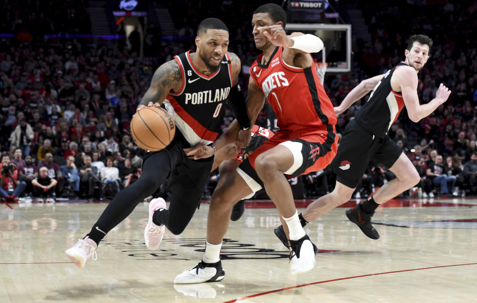 Portland Trail Blazers guard Damian Lillard, left, drives to the basket on Houston Rockets forward Jabari Smith Jr., right, during the second half of an NBA basketball game in Portland, Ore., Sunday, Feb. 26, 2023. Lillard scored a franchise record 71 points as the Blazers won 131-114. (AP Photo/Steve Dykes)