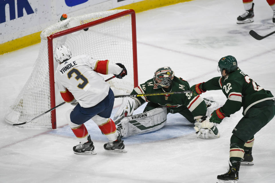 Florida Panthers defenseman Keith Yandle (3) shoots the puck past Minnesota Wild goalie Alex Stalock, center, to score as Minnesota Wild winger Kevin Fiala (22) reaches in to block the shot to during the first period of an NHL hockey game Monday, Jan. 20, 2020, in St. Paul, Minn. (AP Photo/Craig Lassig)