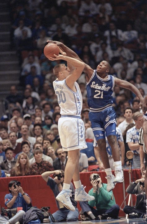 North Carolinas Eric Montross, 00, tries to shoot over Seton Halls Jerry Walker, 21, as Walker blocks the shot during the first half of their ACC-Big East Challenge game at the Meadowlands Arena, Dec. 4, 1991 in East Rutherford, N.J. (AP Photo/Bill Kostroun)