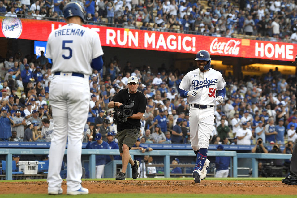 Los Angeles Dodgers' Mookie Betts, right, scores after hitting a solo home run as Freddie Freeman waits to congratulate him during the third inning of a baseball game against the Los Angeles Angels Friday, July 7, 2023, in Los Angeles. (AP Photo/Mark J. Terrill)