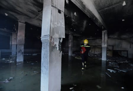 A firefighter is seen at the headquarters of the Islamic Dawa Party which was burnt by the demonstrators during a protest over unemployment, corruption and poor public services, in Najaf