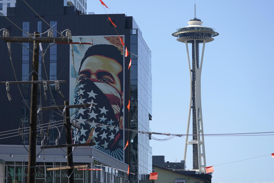 FILE - In this Sept. 2, 2021, file photo, a painting by Shepard Fairey, based on a photo taken by Ted Soqui during a Black Lives Matter protest, is projected onto a building near the Space Needle in Seattle. November's election for Seattle City Attorney pits a Republican versus an extreme liberal candidate who wants to cease most prosecutions of misdemeanor cases, saying the existing system is racist. In many ways the contest has overshadowed the mayoral race as Seattleites will be asked to decide just how far they are willing to go to back social justice policies. (AP Photo/Ted S. Warren, File)