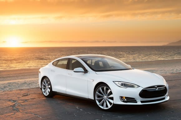 A Tesla Model S parked on a beach.