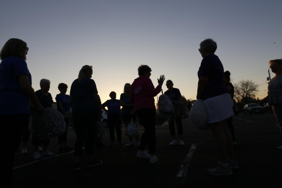 As the sun sets behind them, Kathi Schmeling, a coach and member of the Milwaukee Dancing Grannies, gives feedback to her teammates at a practice in Milwaukee on Wednesday, Nov. 2, 2022. The group has made a comeback after tragedy struck at a Christmas parade last November in Waukesha, Wisconsin. Three Grannies and one group member’s husband were struck and killed when a driver of an SUV sped through the parade route, killing a total of six people and injuring dozens of others. The Grannies, who’ve vowed not to let the tragedy stop them, plan to perform at this year’s Christmas parade in Waukesha. (AP Photo/Martha Irvine)