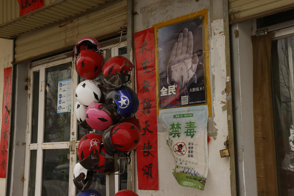 A poster showing a hand and slogans calling for all citizens to take action against evil cults is seen in front of a shop in Peyzawat County in northwestern China's Xinjiang Uyghur Autonomous Region on March 19, 2021. Pedestrians walk by statutes depicting Uyghurs in traditional garb dancing on a shopping street in Aksu, in China's far west Xinjiang region, on March 18, 2021. Four years after Beijing's brutal crackdown on largely Muslim minorities native to Xinjiang, Chinese authorities are dialing back the region's high-tech police state and stepping up tourism. But even as a sense of normality returns, fear remains, hidden but pervasive. (AP Photo/Ng Han Guan)