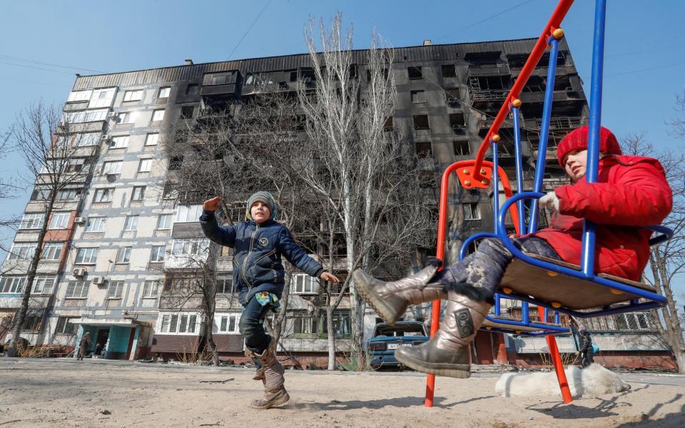 Children play in front of a bombed out apartment block in Mariupol - Alexander Ermochenko/Reuters