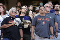 Fans wear T-shirt mocking the Houston Astros during the national anthem before the Astros' baseball game against the Los Angeles Dodgers on Tuesday, Aug. 3, 2021, in Los Angeles. (AP Photo/Marcio Jose Sanchez)