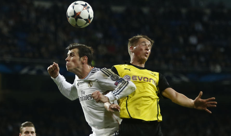 Real's Gareth Bale, left, and Dortmund's Erik Durm go for a header during a Champions League quarterfinal first leg soccer match between Real Madrid and Borussia Dortmund at the Santiago Bernabeu stadium in Madrid, Spain, Wednesday, April 2, 2014. (AP Photo/Andres Kudacki)