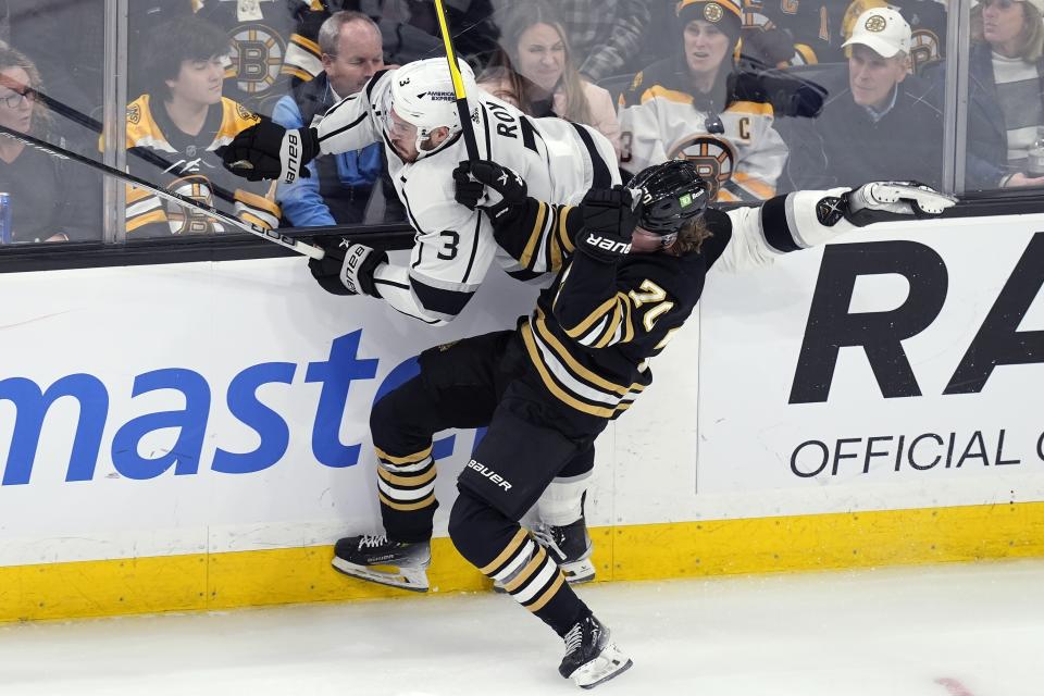 Boston Bruins' Jesper Boqvist (70) checks Los Angeles Kings' Matt Roy (3) into the boards during the third period of an NHL hockey game, Saturday, Feb. 17, 2024, in Boston. (AP Photo/Michael Dwyer)