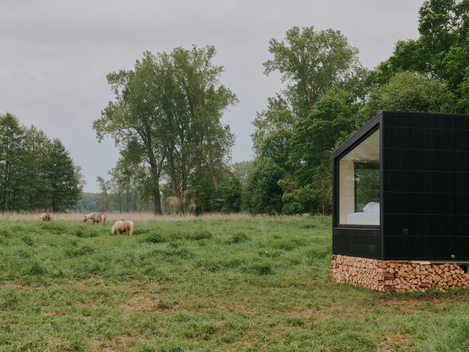 A Raus cabin outside in nature surrounded by trees