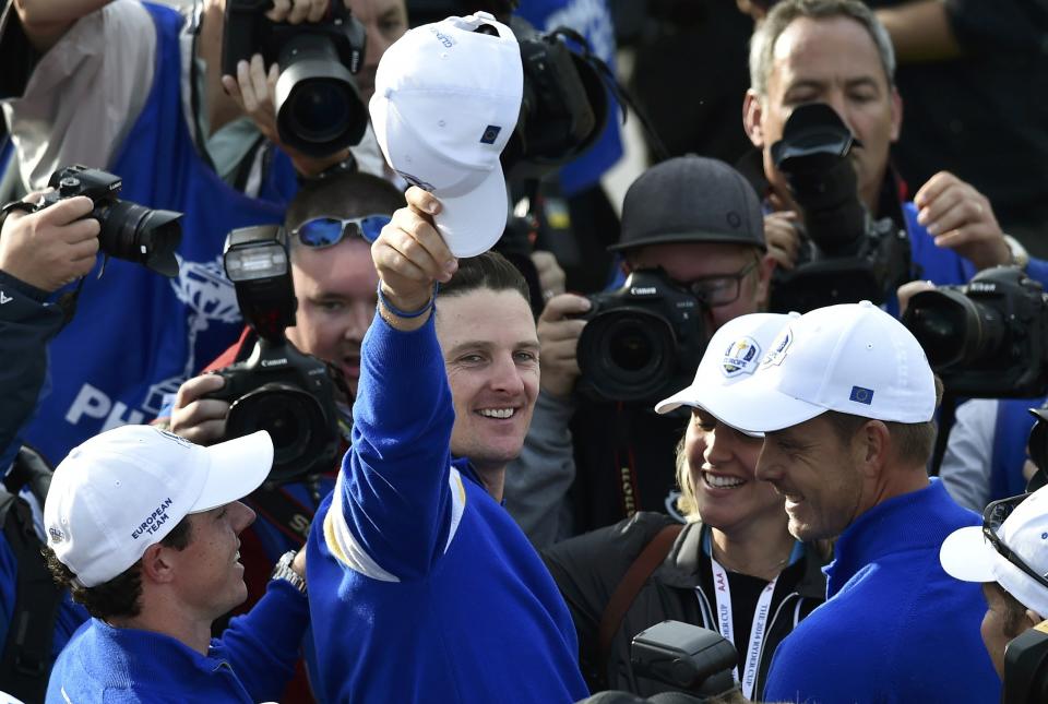 Team Europe players Rory McIlroy (L) and Justin Rose (C) celebrate teammate Jamie Donaldson winning his match against U.S. player Keegan Bradley to retain the Ryder Cup for Europe on the 15th green during their 40th Ryder Cup singles golf match at Gleneagles in Scotland September 28, 2014. REUTERS/Toby Melville (BRITAIN - Tags: SPORT GOLF)