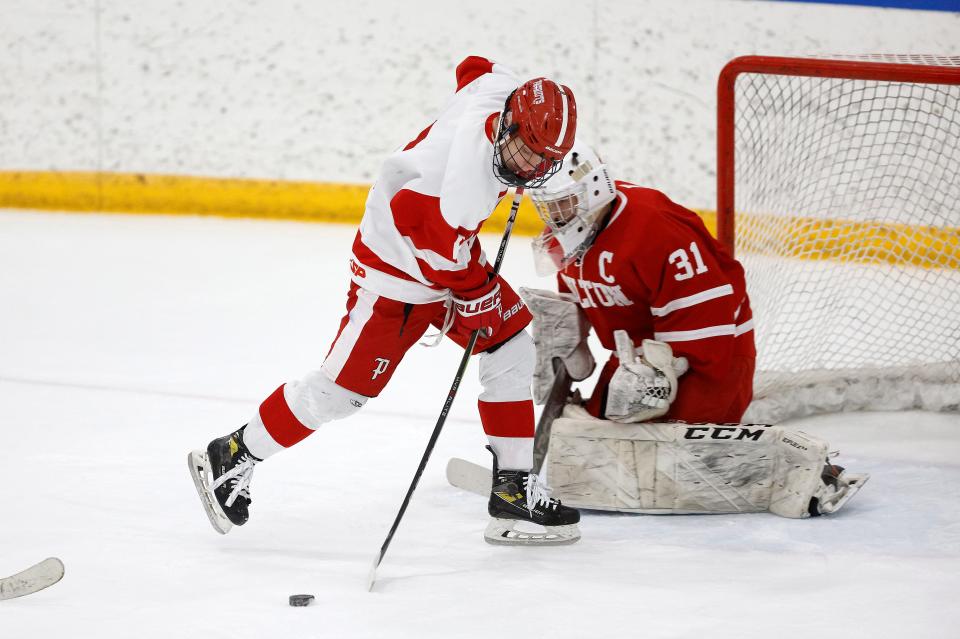 Penfield’s Bobby Kane tries to redirect the puck past Hilton goalie Aiden Hill.