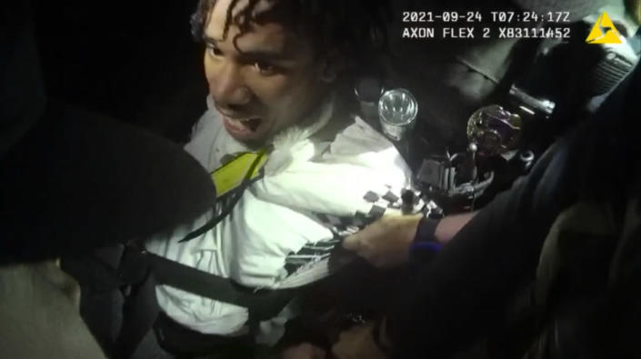 In this image from body camera video provided by Sedgwick County, Cedric “C.J.” Lofton, 17, growls and bites at police outside his home in Wichita, Kan., on Sept. 24, 2021. His foster father said when Cedric returned from the funeral of his grandmother in September, “it got progressively worse,” according to a prosecutor’s report. He described him as “paranoid.” (Sedgwick County via AP)