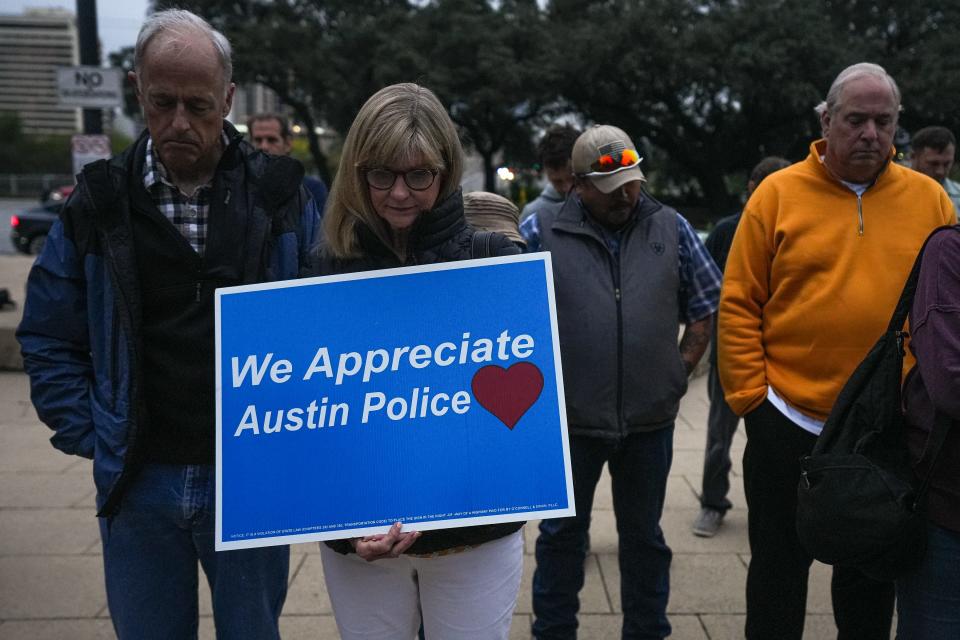 Greg and Pat Herring bow their heads in prayer during a rally for the Austin Police Department and candlelight vigil for slain officer Jorge Pastore at City Hall on Sunday.
