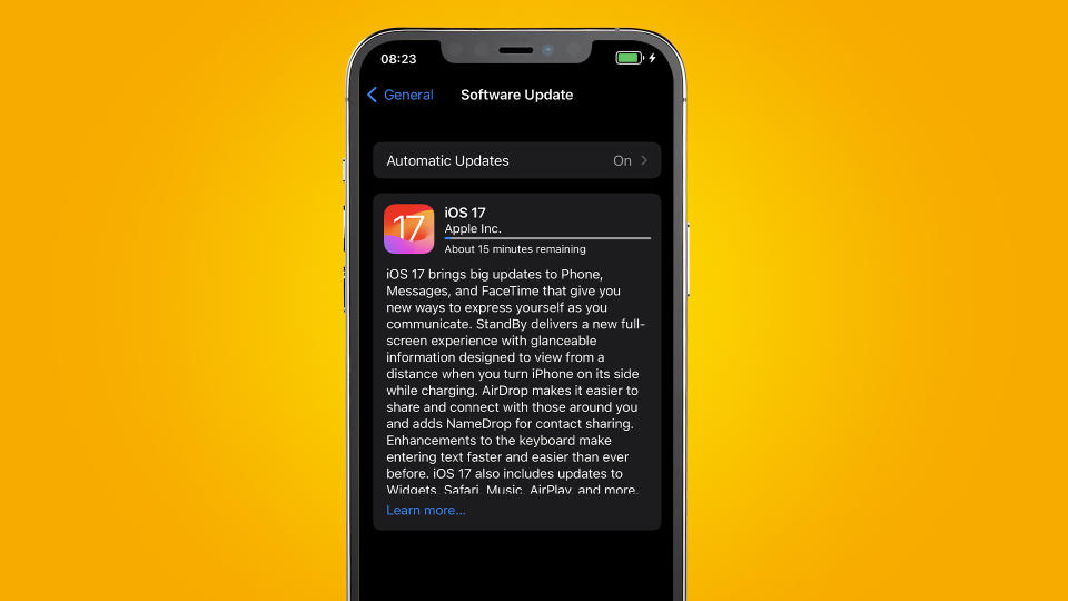 An iPhone on an orange background showing iOS 17 installing