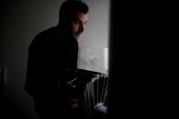 Tango dancer and musician Nicolas Ponce poses for a portrait as he plays the bandoneon inside a plant shop he started after the COVID-19 pandemic lockdown closed dance venues in Buenos Aires, Argentina, Friday, June 4, 2021. The essence of tango, he said, is what makes it so difficult to perform in the current health emergency. (AP Photo/Natacha Pisarenko)