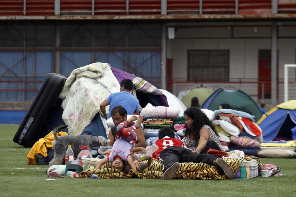 People camp out on a soccer field in Iquique, Chile, Friday, April 4, 2014. Coastal residents of Chile's far north have spent sleepless nights outside their homes as aftershocks continued following a magnitude-8.2 earthquake early in the week that damaged several thousand homes and caused six deaths. (AP Photo/Luis Hidalgo).