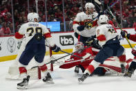 Washington Capitals goaltender Ilya Samsonov (30) reaches for the puck with Florida Panthers right wing Claude Giroux (28), centers Aleksander Barkov (16) and Sam Reinhart (13) around him during the second period of Game 4 in the first round of the NHL Stanley Cup hockey playoffs, Monday, May 9, 2022, in Washington. (AP Photo/Alex Brandon)
